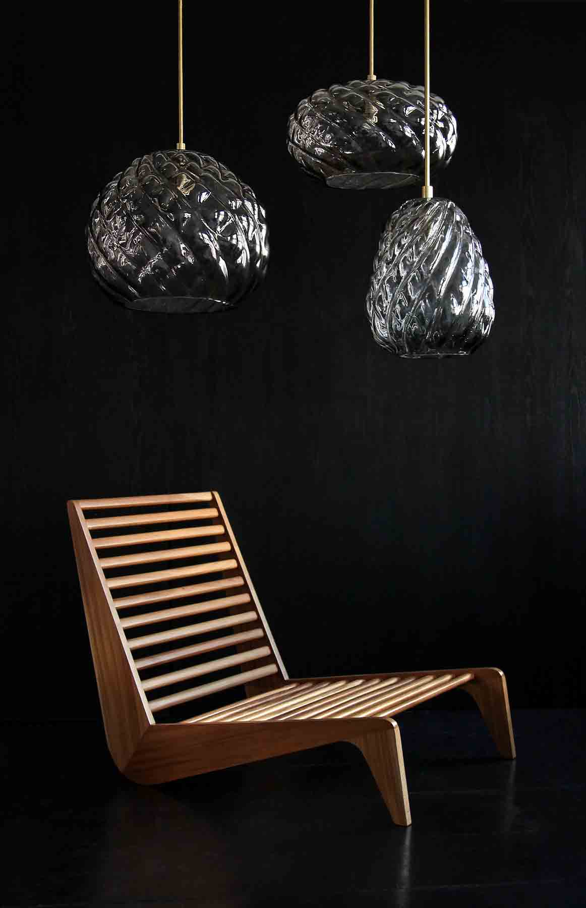 a modern cluster of handblown glass pendant lights in smoke glass with a luteca chair