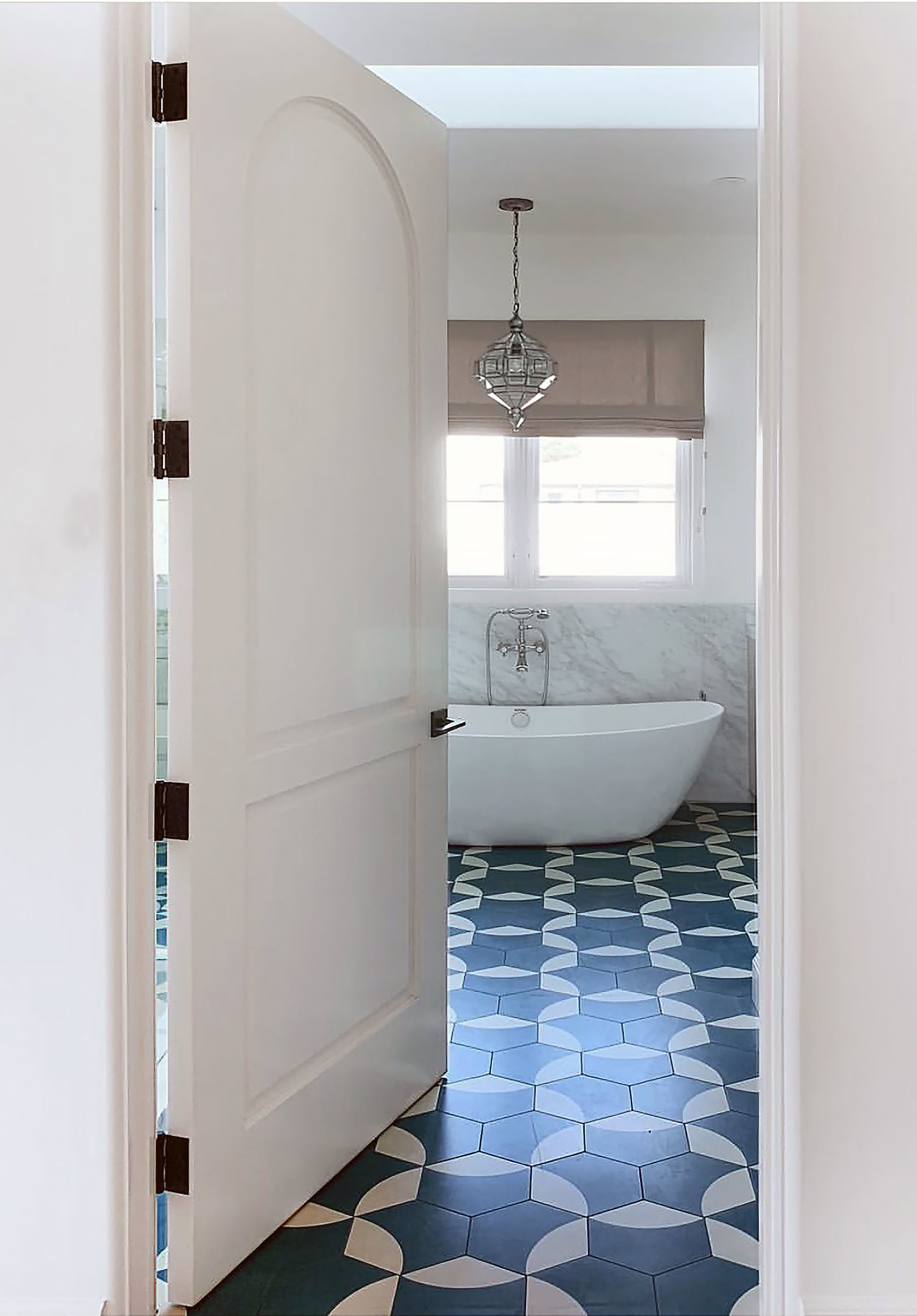 bathroom inspiration, l'aviva home's alhmabra lantern sitting over a beautiful bathtub. Interior design by Jordan Shields Design.