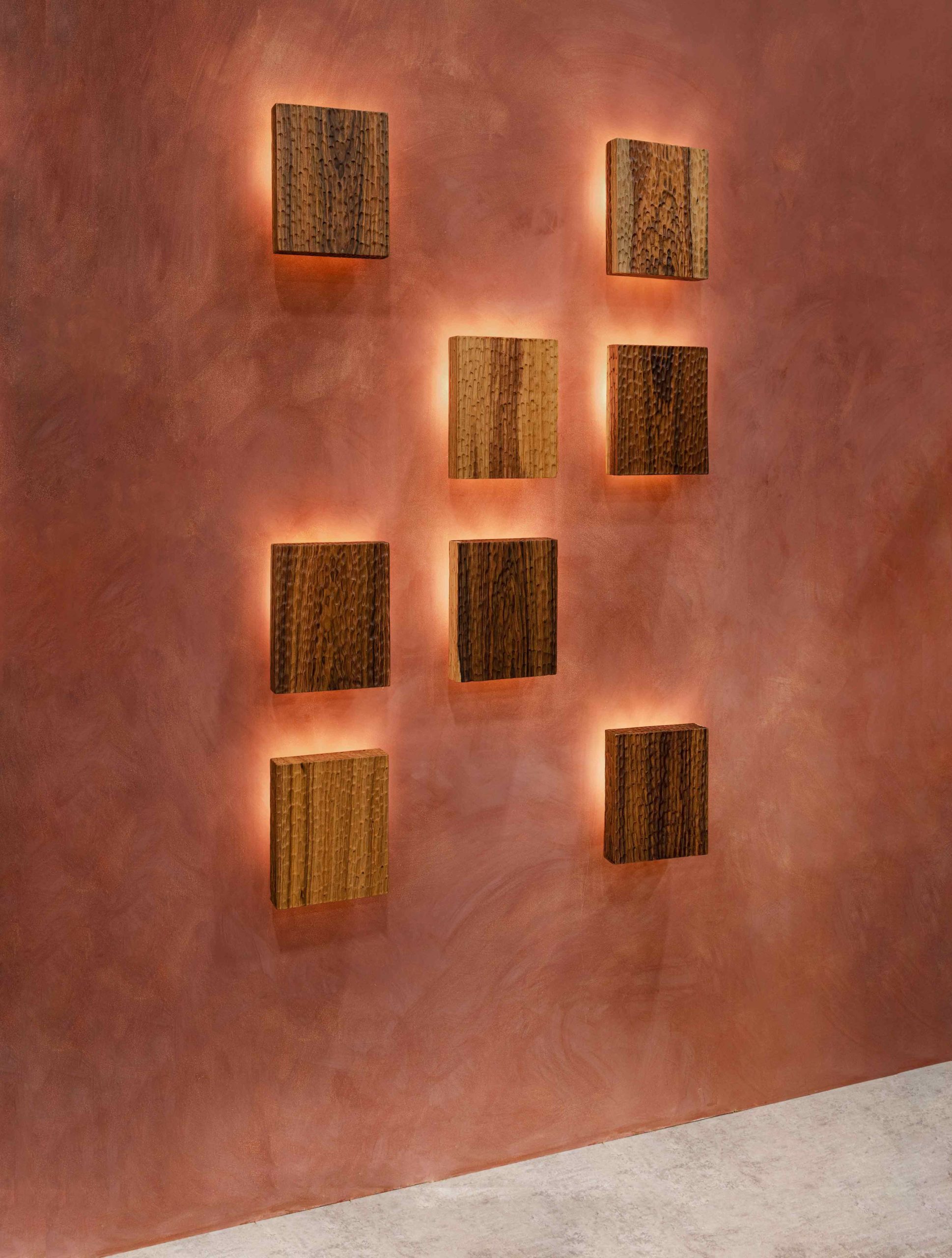 Tropical hardwood sconces on terra cotta lime washed wallls and concrete floors