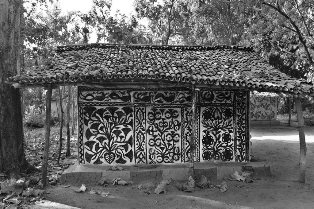 Khovar_workshop_03 This collection draws its inspiration from the tribal villages of Hazaribagh in Northeastern India, where the mud walls of village homes are adorned with expansive, figurative murals. The process begins with a dark earthen base, layered with pale clay. Before the top layer dries, women in the villages brush away the lighter clay using broken combs or their fingers, revealing fluid, organic silhouettes.